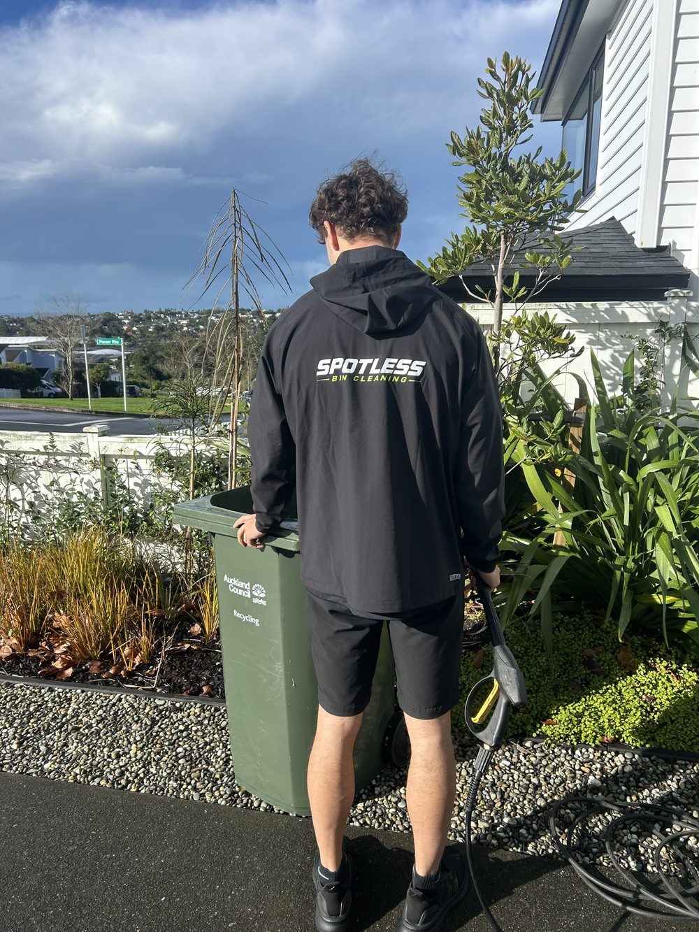 Spotless Bin Cleaning operator cleaning a kerbside bin in Auckland